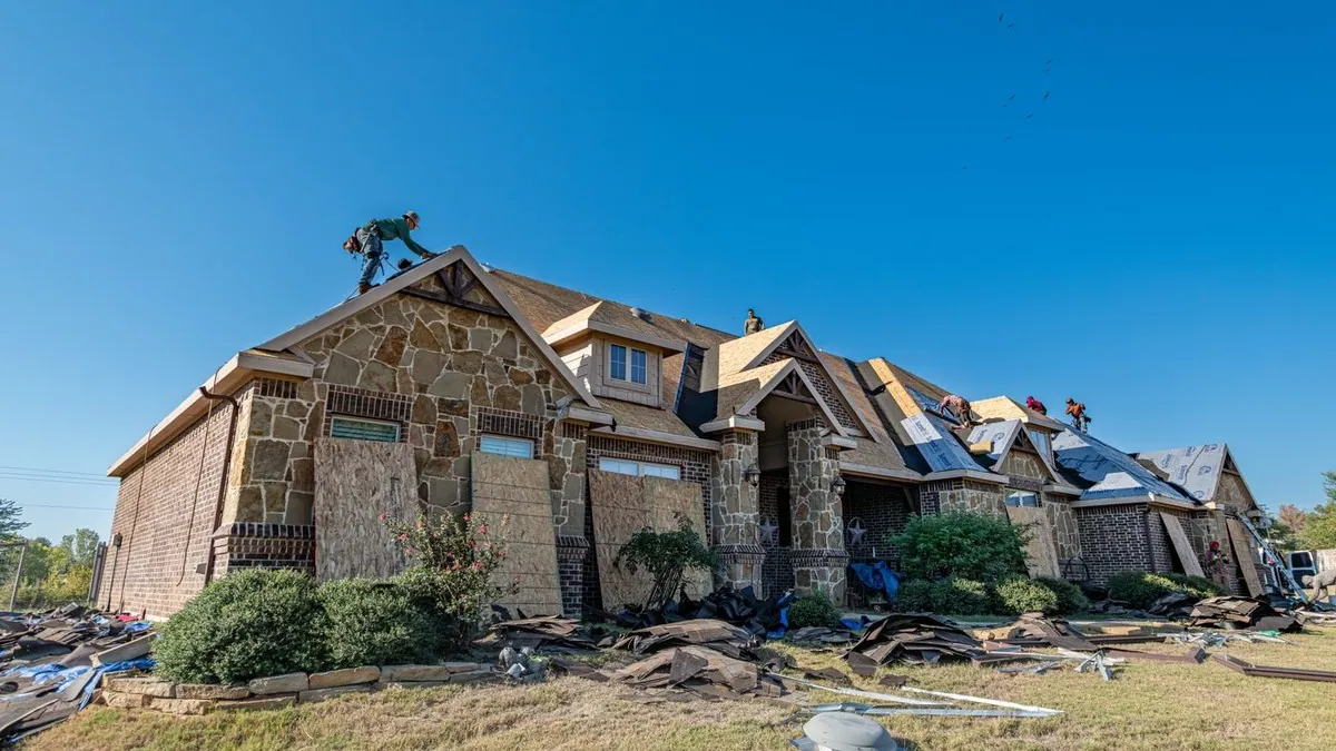 Roofing crew replacing the roof of a brick home in Weatherford, Texas
