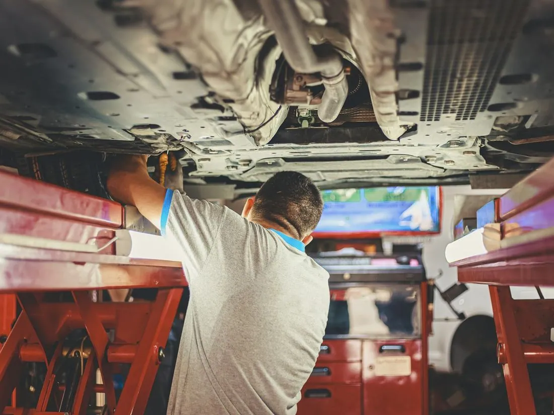 Mechanic working under a car on a lift