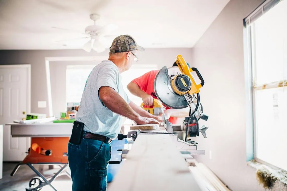 Contractor cutting wood with a miter saw