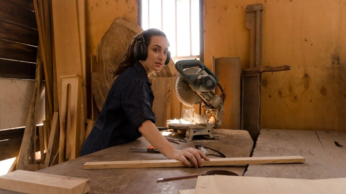 Carpenter working beside a miter saw inside a timber workshop