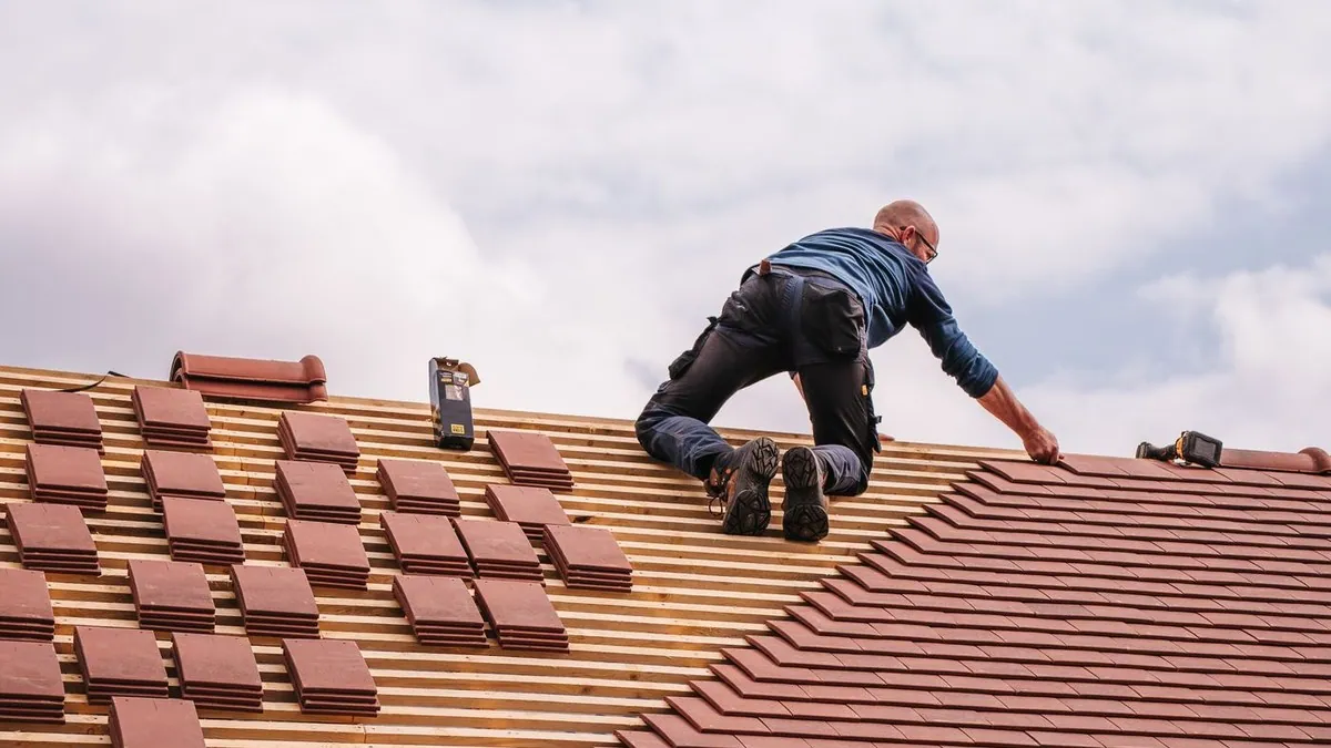 Roofer installing tiles on a residential roof