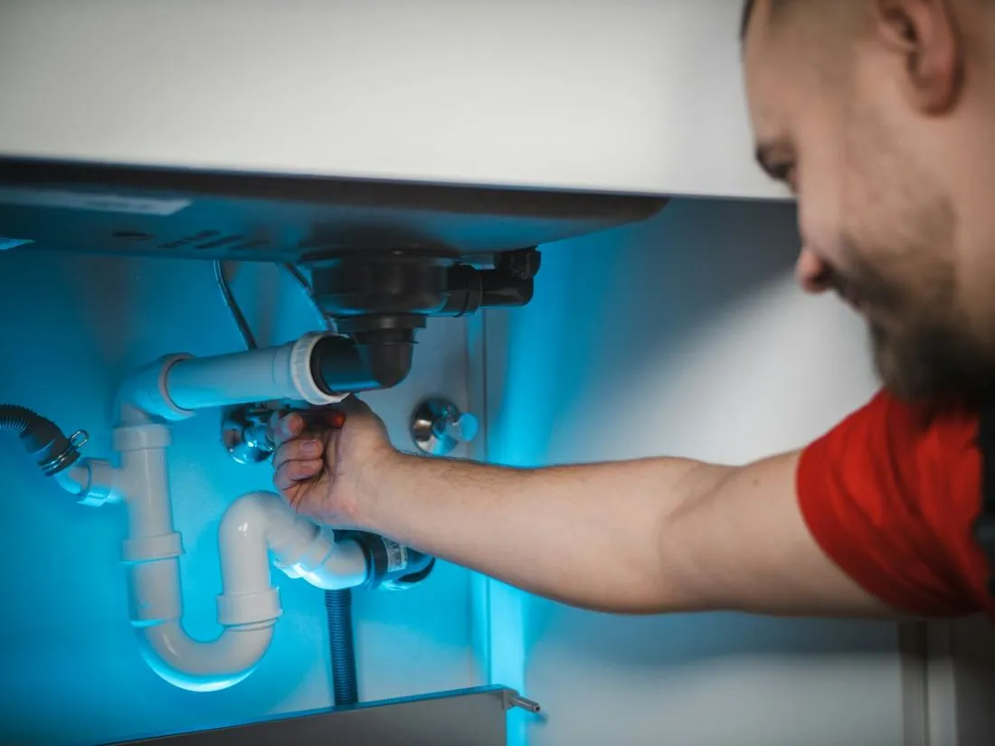 Plumber working under a kitchen sink